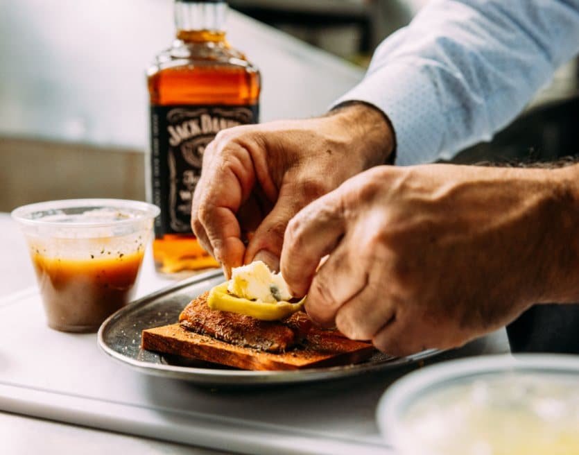 Chef plating a whiskey-glazed dish