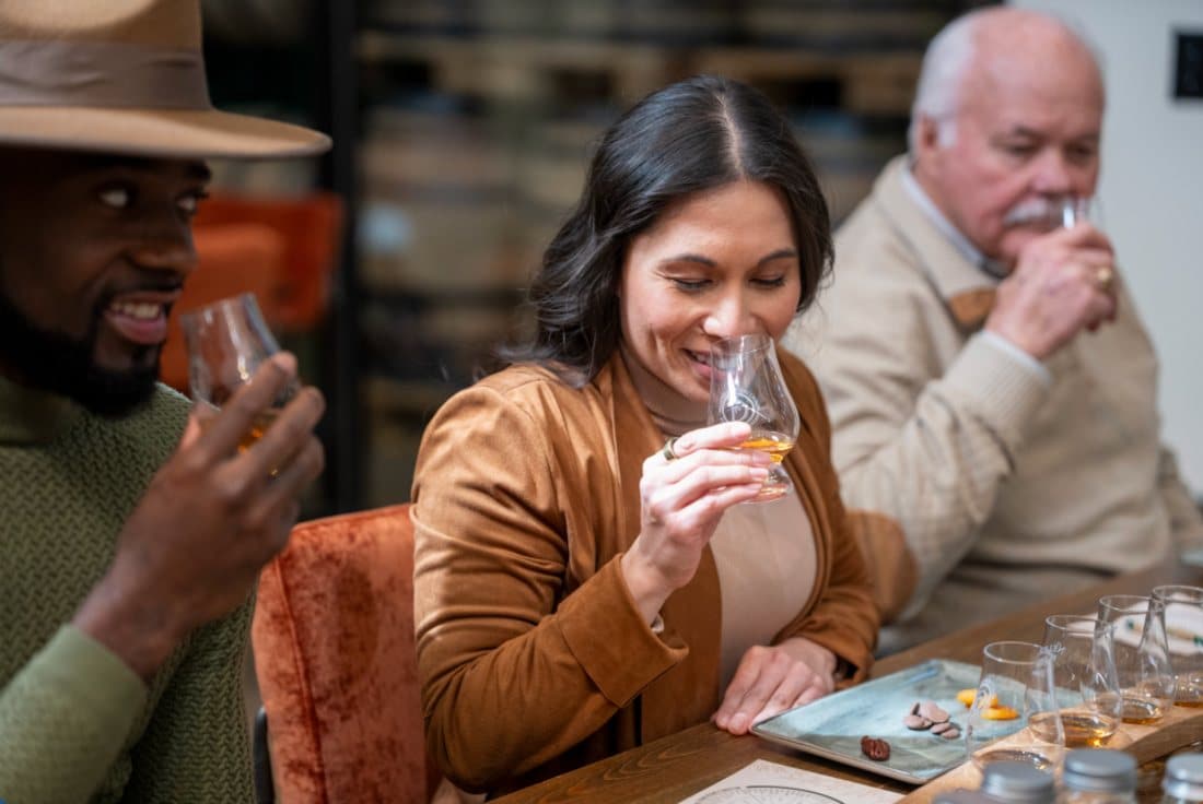 Guests nosing a whiskey flight at a distillery tasting